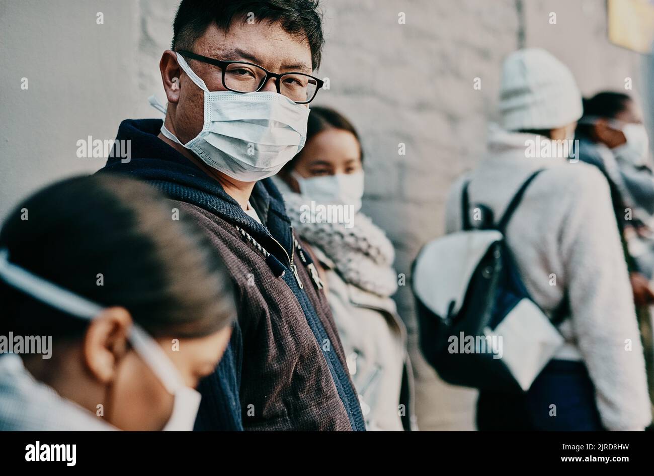 Compliance, Sicherheit und Reisebeschränkungen mit einer Gruppe, die Schlange steht, um einen Impfstoff oder eine Auffrischungsimpfung zu erhalten. Anforderung für Corona Gesichtsmaske in einem Stockfoto