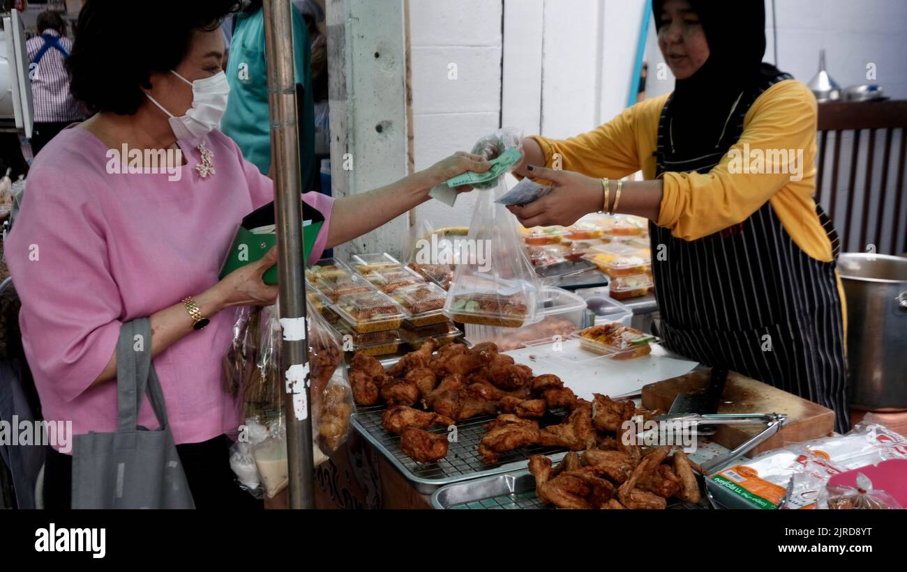 Geldwechselhände Sidewalk Street Food Vendor an der Petuberri Road in Bangkok, Thailand Stockfoto