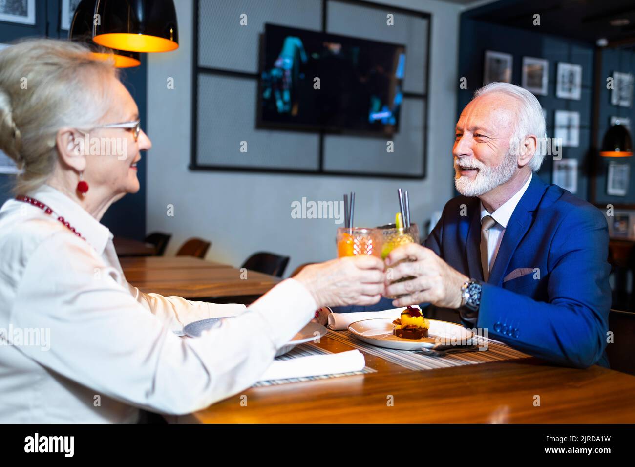 Ältere Paare lieben es, Cocktails zu trinken und in einem Restaurant zu Abend zu essen Stockfoto