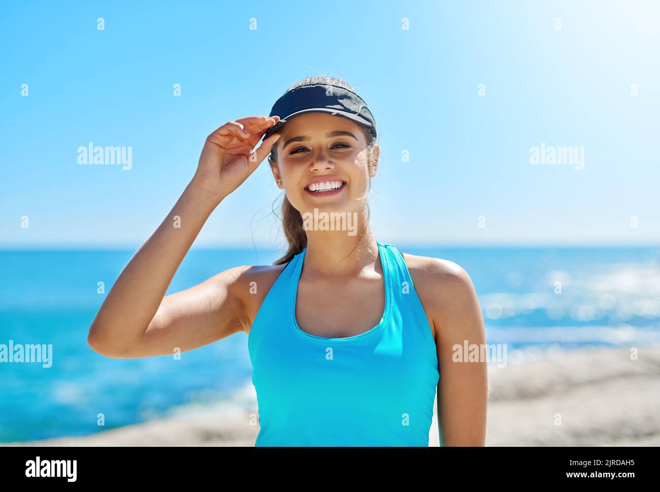 Ich bin gekleidet für ein Training unter der Sonne. Eine sportliche junge Frau am Strand für ihr Training. Stockfoto