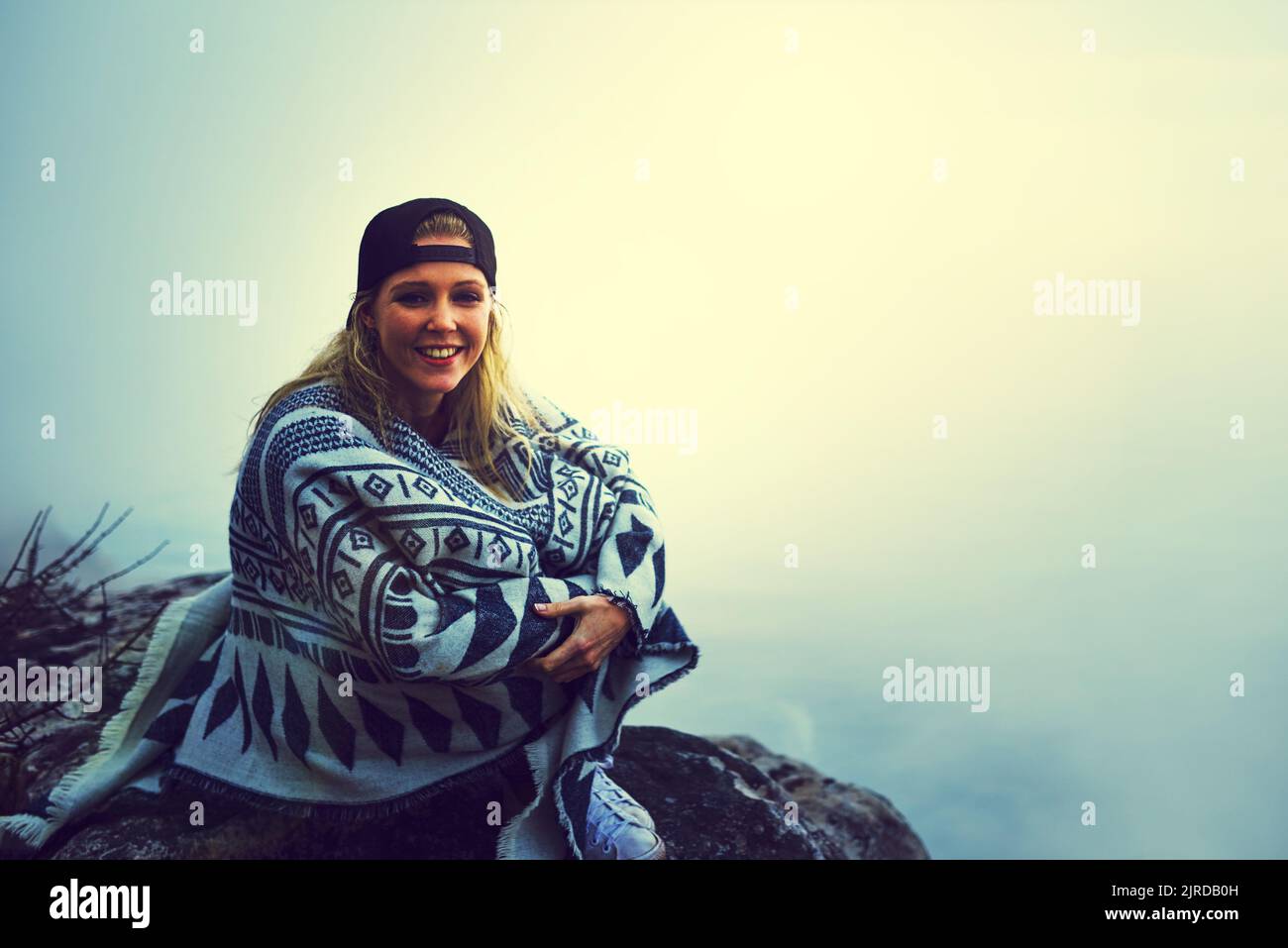 Ich lebe nur im Moment. Porträt einer glücklichen jungen Frau, die einen nebligen Blick von der Spitze eines Berges aus bewundert. Stockfoto