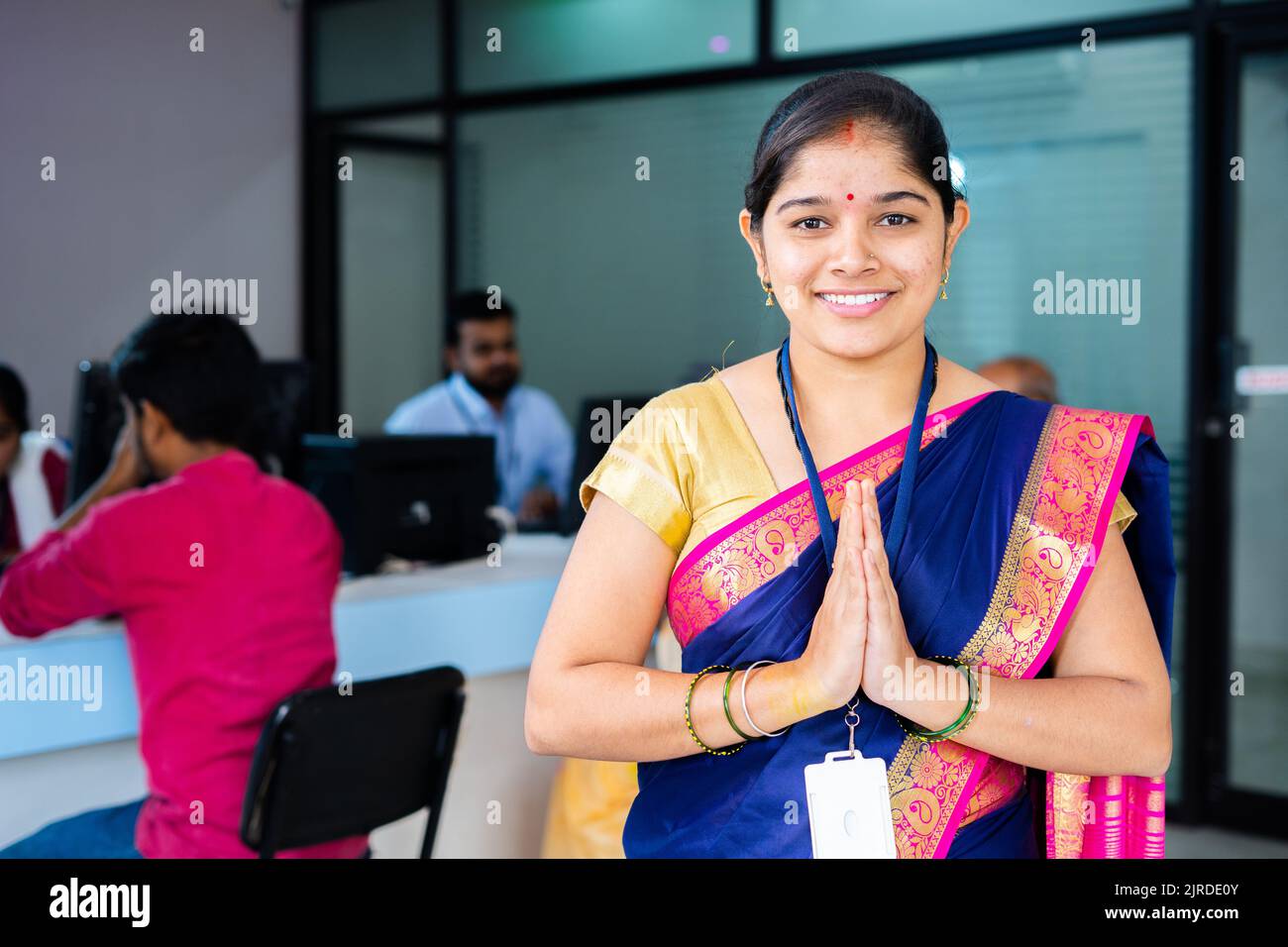 Portraitaufnahme der Begrüßung des glücklichen, lächelnden Bankmitarbeiters durch Namaste, während er vor den Kunden mit der Kamera blickt - Konzept der Dankbarkeit, Begrüßung Stockfoto
