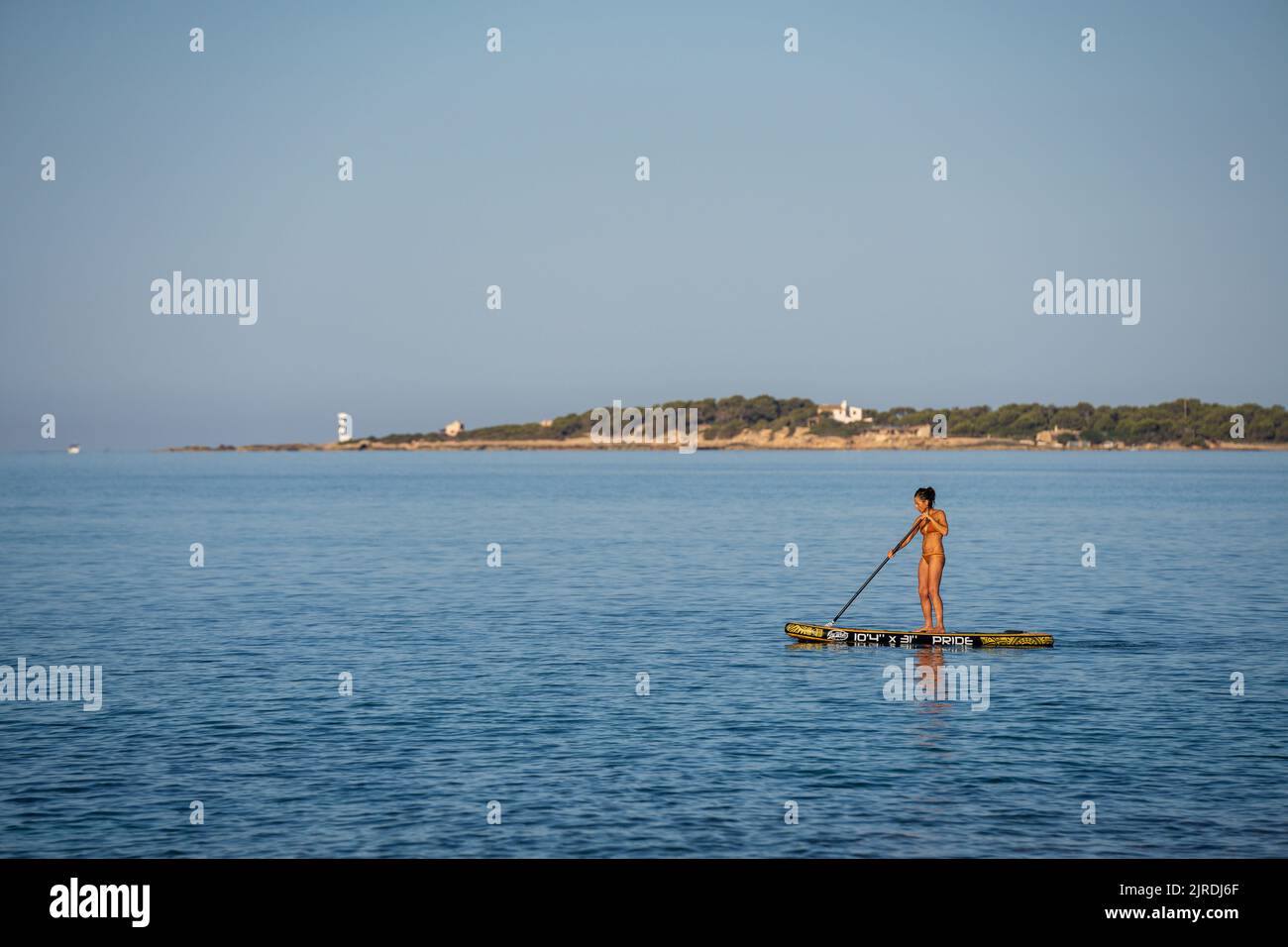 Einsame Frau übt Paddle-Surfen im Mittelmeer, Sa Rapita, Campos, Mallorca, Balearen, Spanien Stockfoto