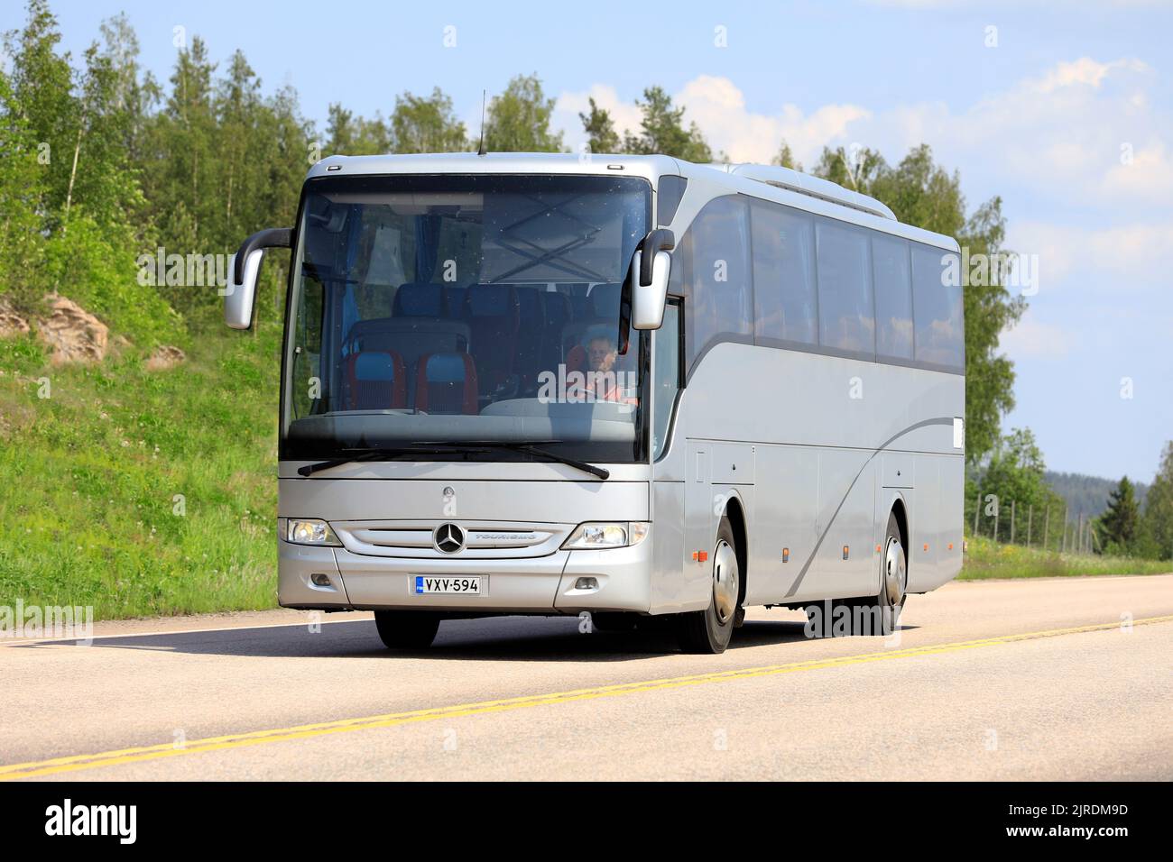 Silberner Mercedes-Benz Tourismo Bus an einem sonnigen Sommertag unterwegs. Orivesi, Finnland. 6. Juni 2019. Stockfoto