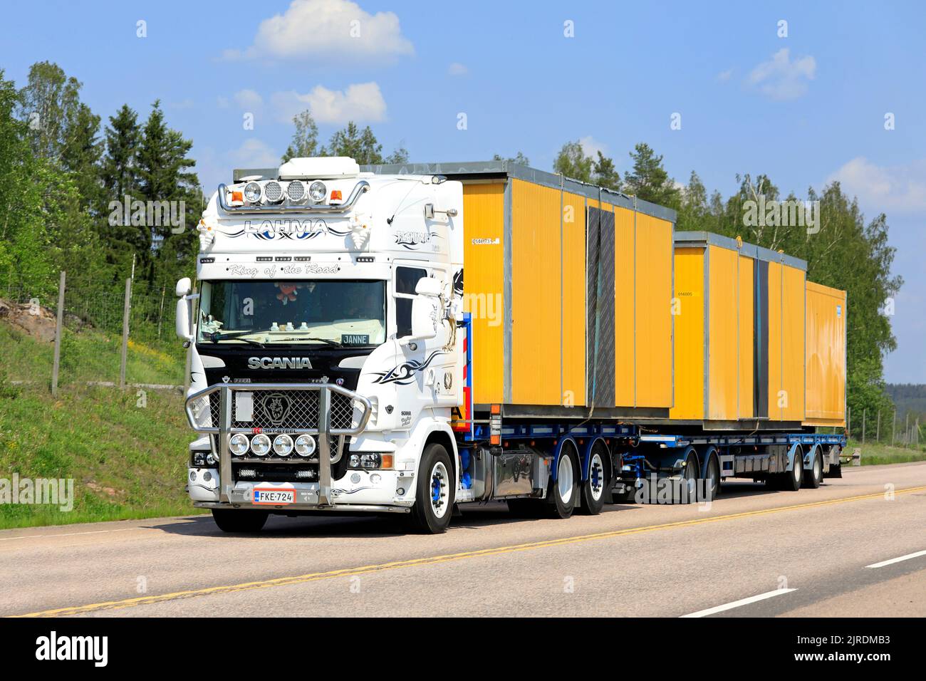 Der weiße, maßgeschneiderte Scania-LKW Lahma-Trans Oy transportiert im Sommer tragbare Kabinen als Breitlasttransport auf der Autobahn 9. Orivesi, Finnland. 6. Juni 2019. Stockfoto