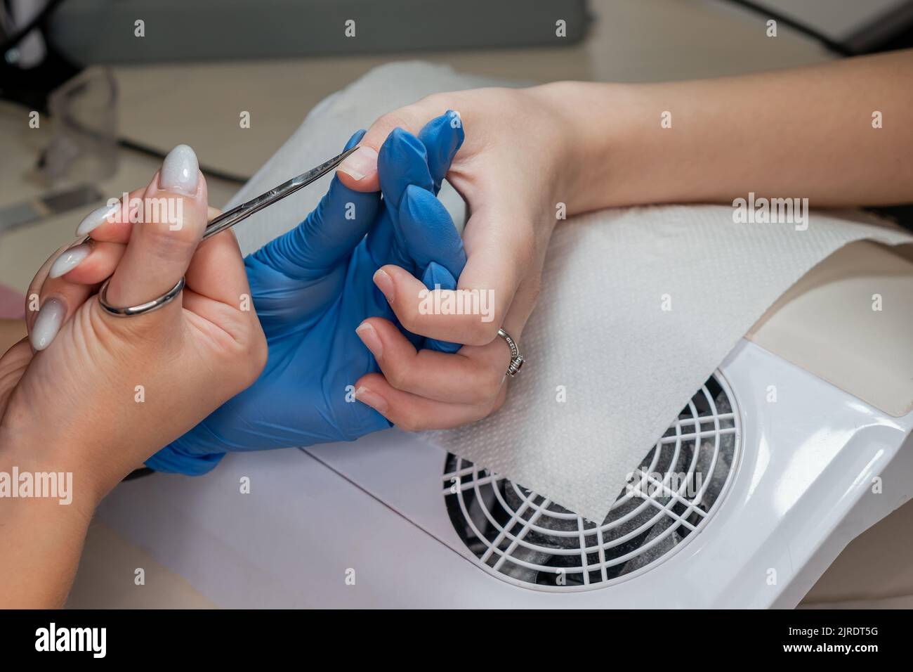 Beauty-Therapeut tut Maniküre auf der Hand der jungen asiatischen Frau. Stockfoto