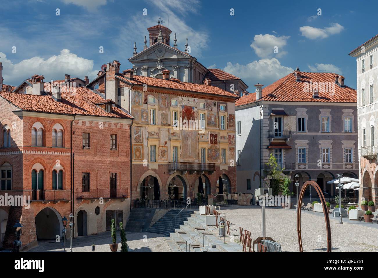 Mondovì, Cuneo, Piemont, Italien - 08. August 2022: Alte mittelalterliche Gebäude mit Mullionfenstern mit Fresken an Backsteinfassaden und Kathedrale in Pia Stockfoto