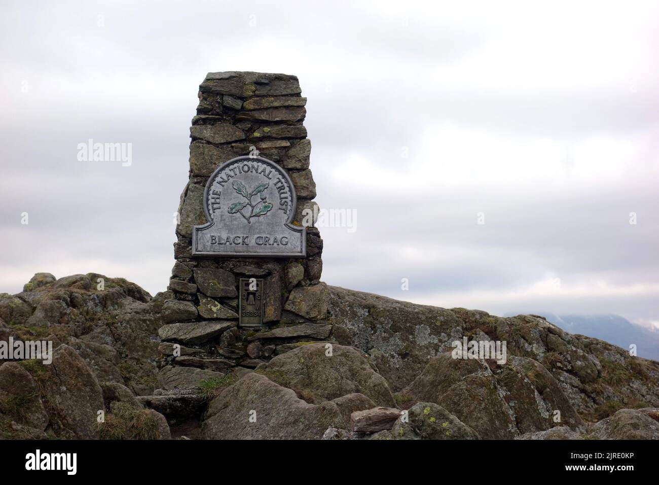 The Stone Trig Point on 'Black Crag' The Summit of the Wainwright 'Black Fell' in der Nähe von Tarn Hows im Lake District National Park, Cumbria, England. VEREINIGTES KÖNIGREICH. Stockfoto