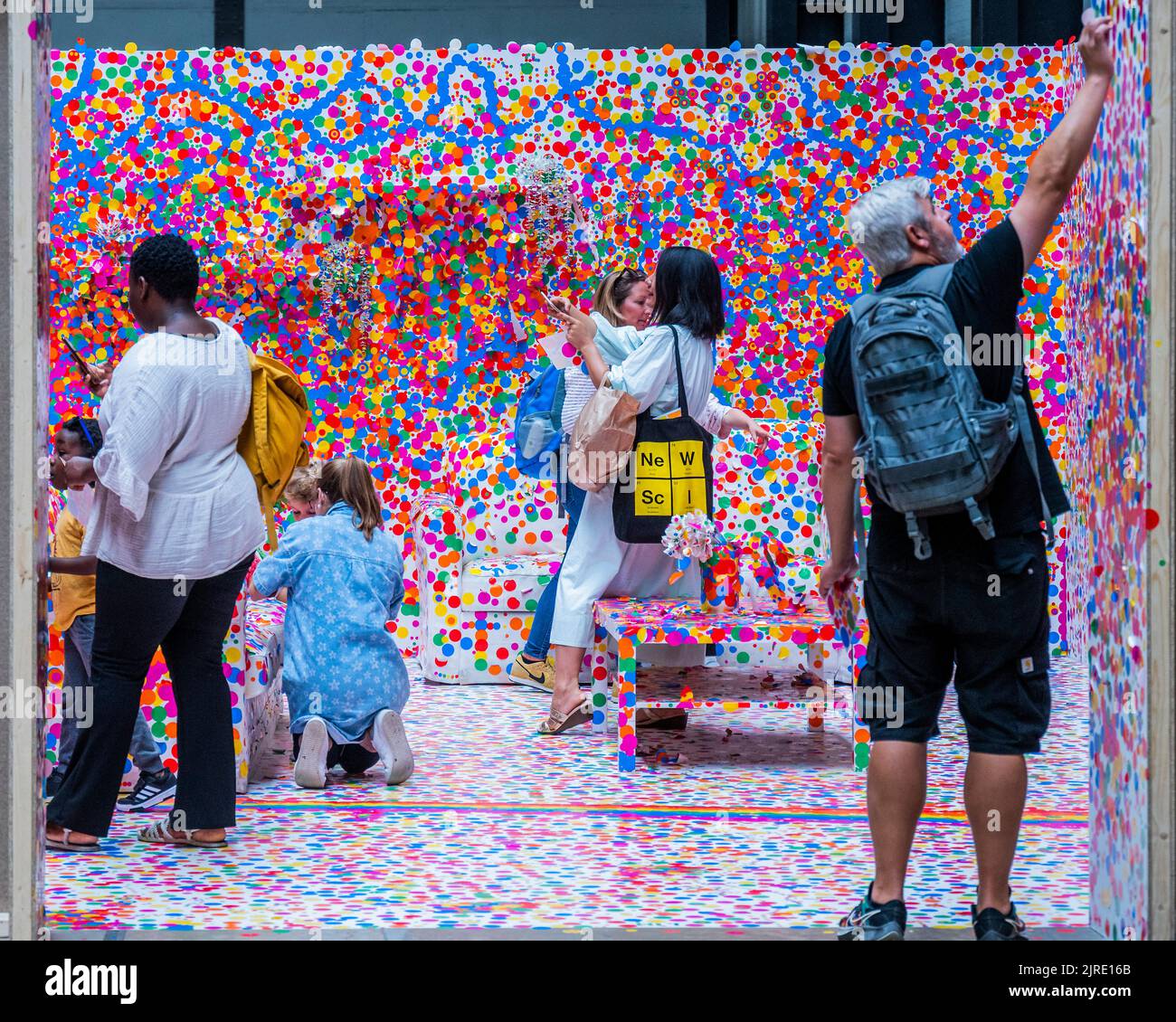 London, Großbritannien. 23. August 2022. Die letzte Chance in dieser Woche, am UNIQLO Tate Play teilzunehmen: Der Auslöserraum von Yayoi Kusama, in dem Besucher eine komplett weiße Wohnwohnung in ein Meer aus bunten Punkten verwandeln. Besucher erhalten ein Blatt mit bunten ‘dot' Stickern, die den Raum in der Turbinenhalle zum Leben erwecken sollen. Kredit: Guy Bell/Alamy Live Nachrichten Stockfoto