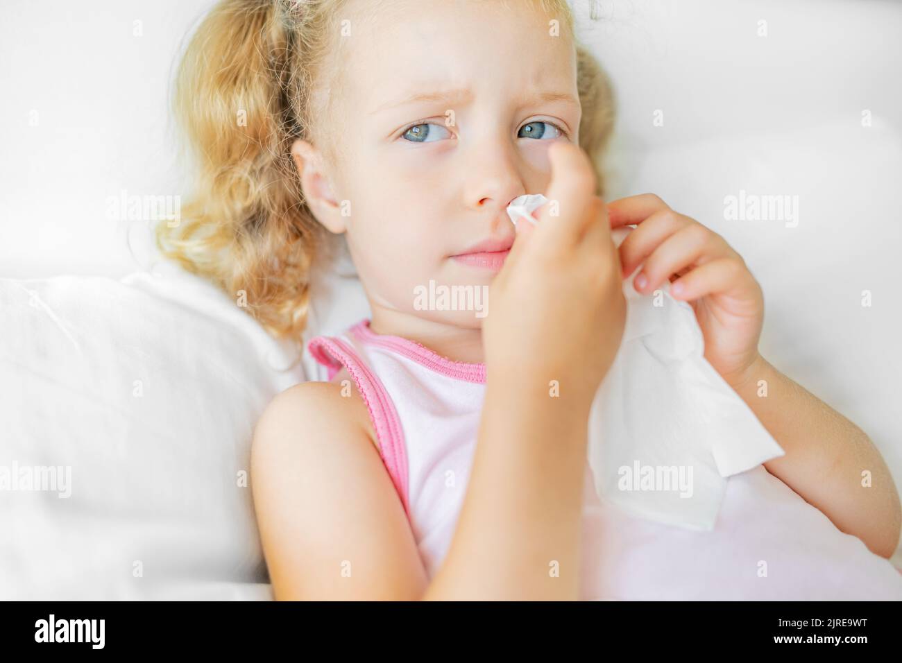 Das Kind wischt seine Nase mit einer Serviette ab. Stockfoto