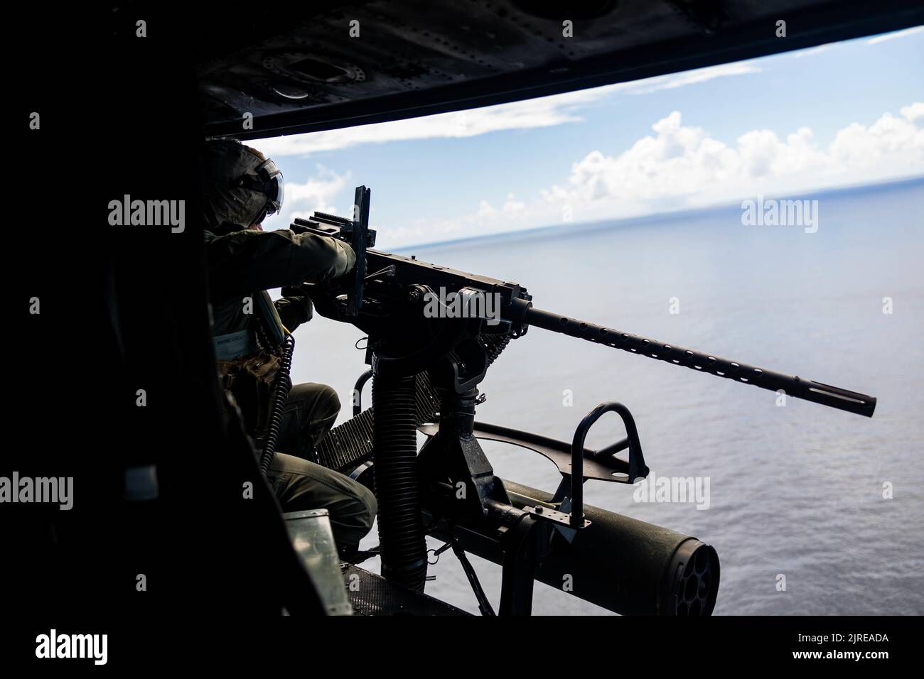 US Marine Corps Gunnery Sgt. Joe Thomas, Crew-Chef bei Marine Light Attack Helicopter Squadron (HMLA), 469 feuert einen GAU-21 vor der Küste von Okinawa, Japan, 3. August 2022. HMLA-469 führte eine Streikkoordinations- und Aufklärungsübung durch, um die Leistungsfähigkeit und Letalität im gesamten Geschwader zu erhöhen. (USA Marine Corps Foto von PFC. Justin J. Marty) Stockfoto