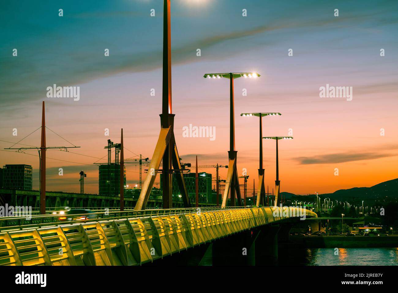 Rákóczi Brücke über den Fluss gegen Neubaugebiet bei Sonnenuntergang Stockfoto