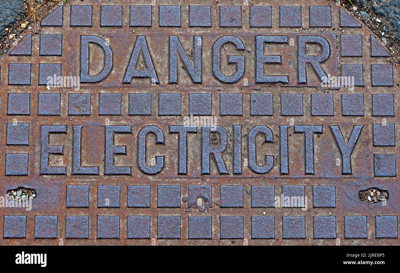 Gefahr - Elektrizität, rostendes Gusseisennetz, England, Großbritannien Stockfoto
