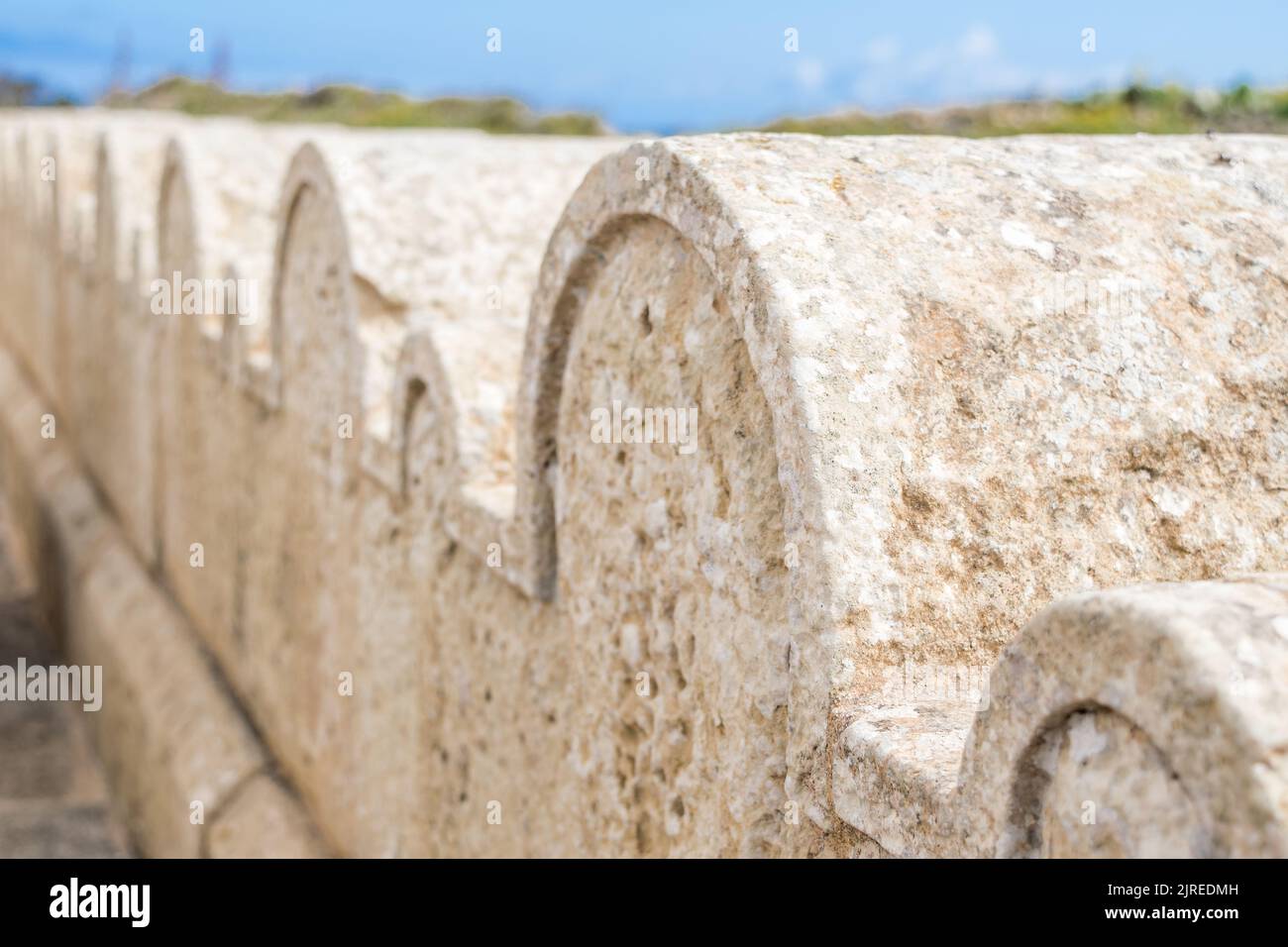 Ein Kalksteinzaun oder eine Grenze, die mit kleinen und großen Steinbögen um die St. Dimitri-Kapelle im ländlichen Dorf Gharb, Gozo, Malta, geschmückt ist Stockfoto