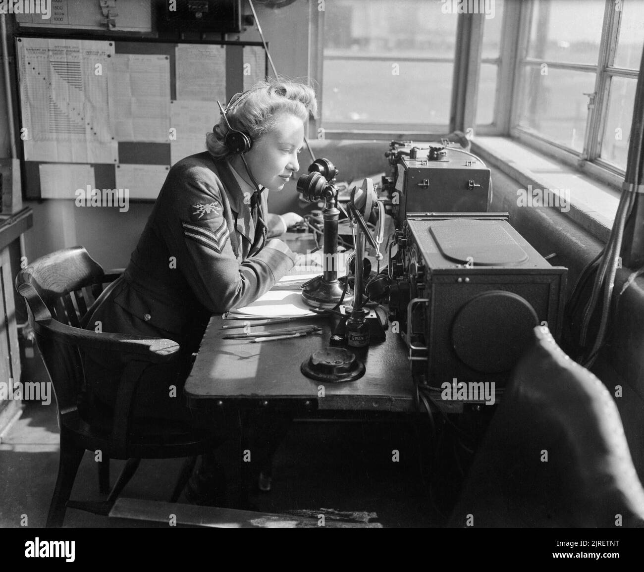 Royal Air Force Bomber Command, 1942-1945. Eine WAAF Corporal radio Telefonie operator kommunizieren mit Flugzeugen aus den watch Büro an ein Bomber Command Station. Stockfoto