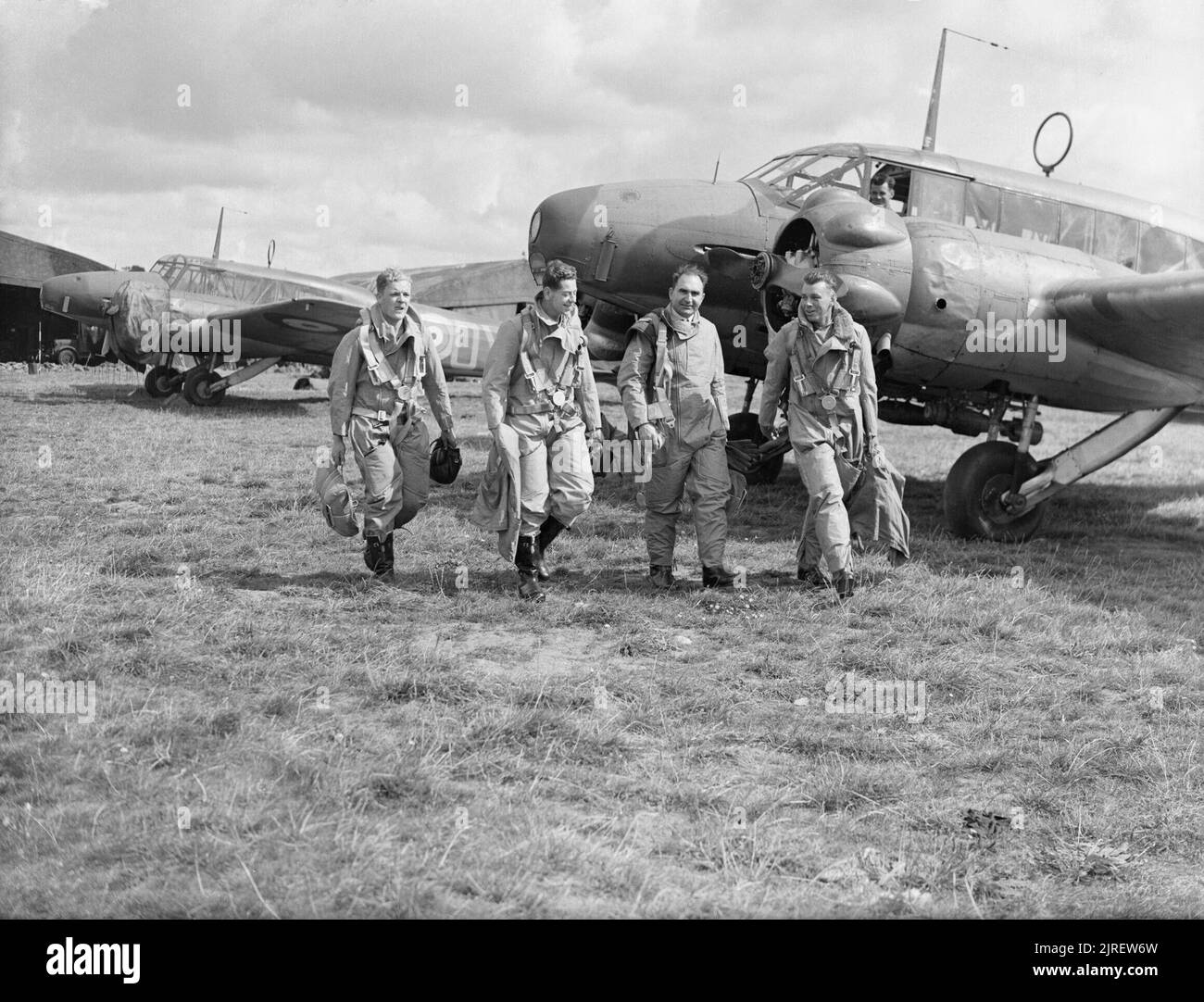 Royal Air Force Coastal Command, 1939-1945. Piloten von Nr. 320 (Niederländisch), oder 321 (Niederländisch) Squadron RAF zu Fuß zu ihren Avro Anson bei Carew Cheriton, Pembrokeshire. Beide Staffeln wurden am 1. Juni 1940 von den Mitgliedern der niederländischen Royal Naval Air Service, die nach der Invasion von Holland nach Großbritannien geflohen waren, gegründet. 320 Squadron, an Leuchars, Fife, wurde mit 321 Squadron, die schon fliegen Ansons an Carew Cheriton, und wer hat 320 Squadron mit Besatzungen verbunden. Eine Anson im Hintergrund trägt noch die Maßeinheit Buchstaben ('OY") von Nr. 48 Squadron RAF, mit Wh Stockfoto