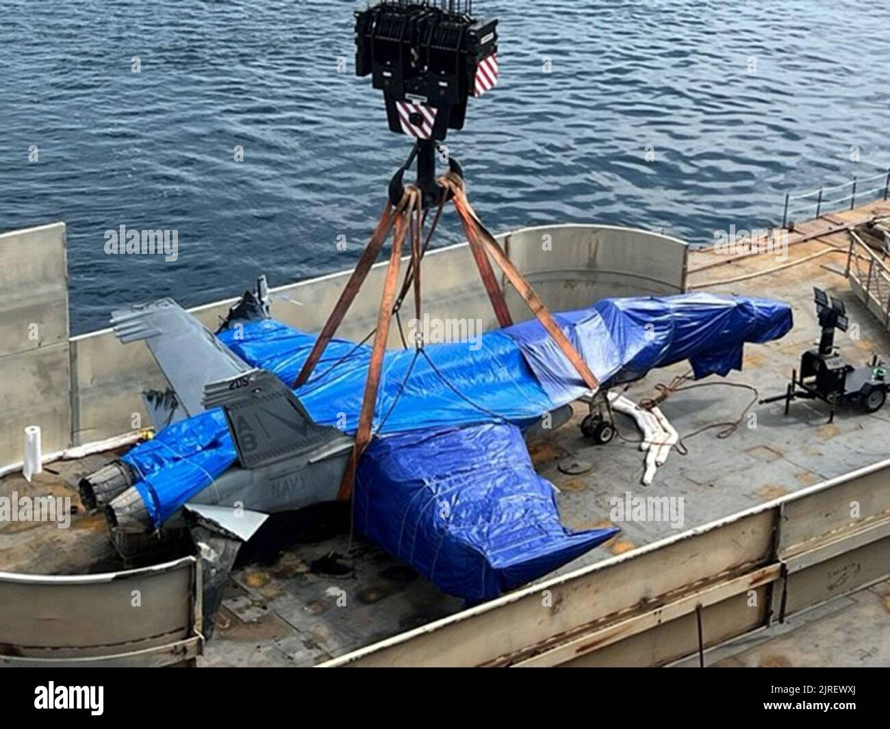 Blick auf eine F/A-18E Super Hornet, aufgenommen am 16. August 2022, vor der Küste Siziliens, Italien, als sie auf das große mittelschnelle Roll-on-Roll-off-Schiff USNS Mendonca (T-AKR 303) des Military Sealift Command für den Transport in die Vereinigten Staaten abgesenkt wurde. Das Flugzeug, das Anfang des Jahres bei starkem Wetter vom Flugzeugträger USS Harry S. Truman (CVN 75) abgeblasen wurde, wurde mit einem ferngesteuerten Fahrzeug CURV-21 9.500 Fuß unter dem Mittelmeer geborgen, um spezielle Takelage- und Aufzugslinien an das Flugzeug zu befestigen. Foto über U.S. Navy/UPI Stockfoto