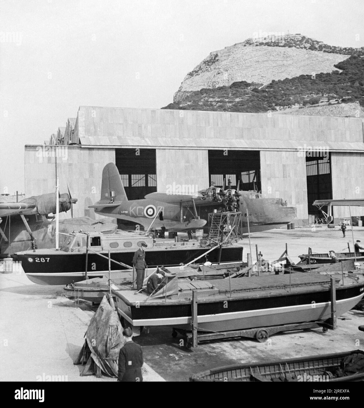 Royal Air Force in Malta, Gibraltar und das Mittelmeer, 1940-1945. Belebte Szene von der Helling nördlich an der Front, Gibraltar. Im Vordergrund verschiedene RAF marinecraft Wartung unterzogen werden. Geparkt hinter ihnen sind ummantelt Consollidated Catalinas von Nr. 202 Squadron RAF, während vor dem Hangar, ein Motor Service wird auf kurze Sunderland Mark I, L5798 "KG-B', der Nr. 204 Squadron RAF, in Bathurst, Gambia. Zwischen 1941 und 1944, dieses Gerät regelmäßig alliierten Konvois zwischen Gibraltar und West Afrika begleitet. Stockfoto