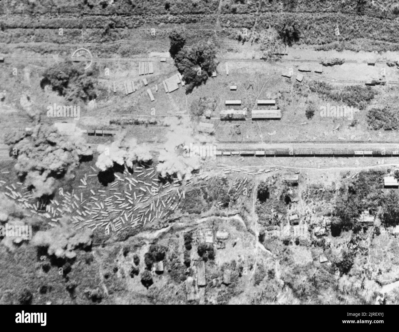 Royal Air Force in den Fernen Osten, 1941-1945. Bomben auf Ywataung-Myitkyina Bahnstrecke in der Nähe des Irrawaddy Fluss in Birma explodieren, bei einer Razzia von der Bristol Blenheims der Nr. 167 Wing RAF Betrieb von Flugplätzen in Indien. An der linken Seite kann teak Protokolle, wahrscheinlich durch die japanischen Lkw befördert gesehen werden und off-geladen Floating auf dem Irrawaddy in der Monsunzeit zu erwarten. Stockfoto
