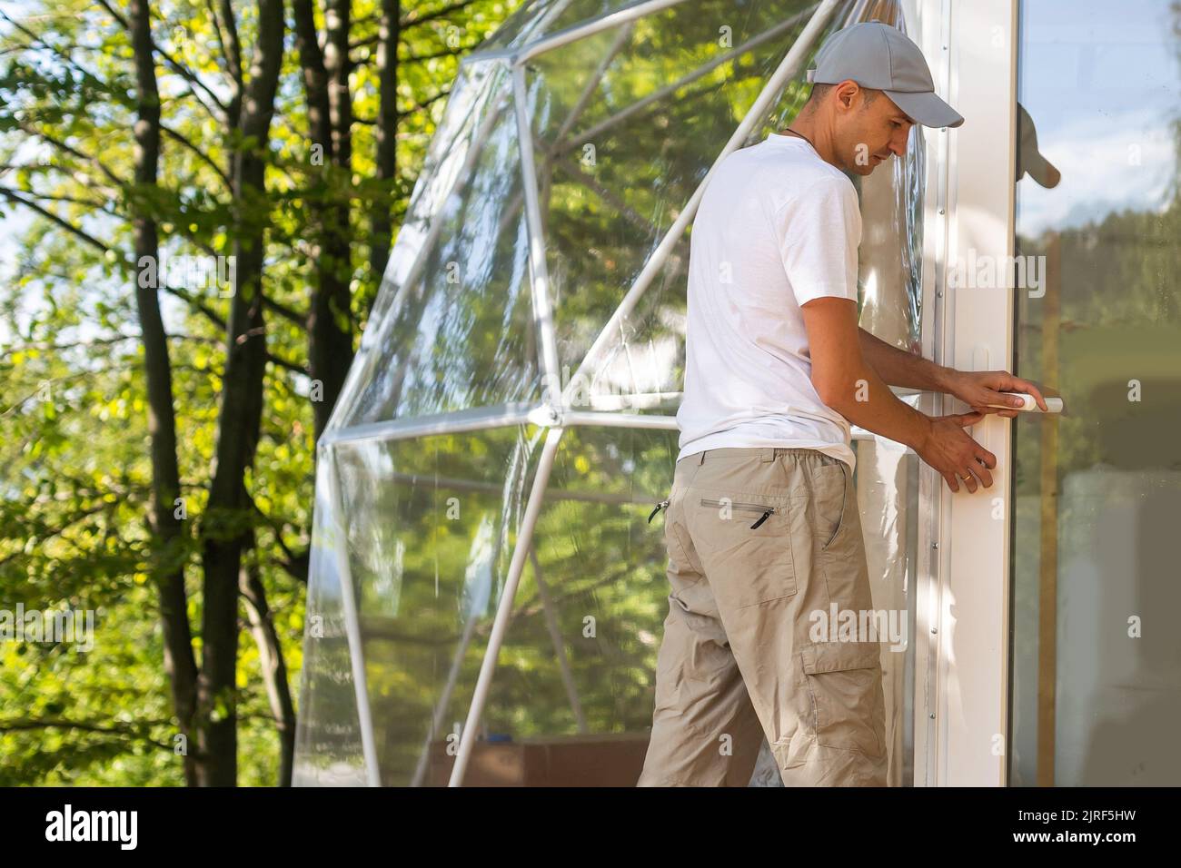 Der Meister baut die Kuppel. Außen kugelförmige Glamping-Kuppel. Hemispherische Struktur Geodätische Polyeder der Gitterschale. Camping House Hotel Partyzelt Stockfoto