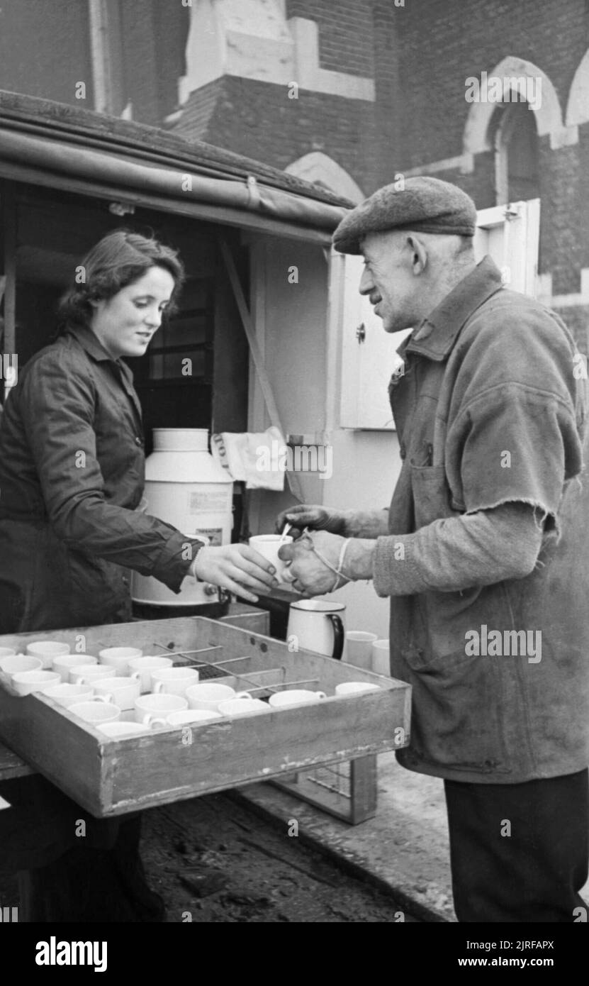 Rachel Bingham der freiwilligen Dienst der Frauen (WVS) serviert Tee von Ihrem mobilen Kantine in London 1941. Rachel Bingham serviert Tee hinten an die WVS Kaffee Auto zu einem Mann, der geholfen hat, bis die Trümmer und Schutt durch einen Luftangriff in dieser Gegend von London, 1941 verursacht zu löschen. Stockfoto