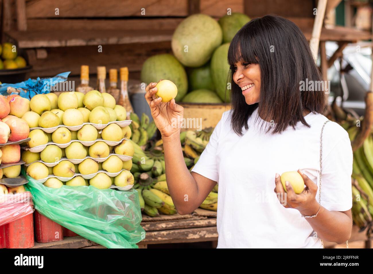 Hübsche afrikanische Dame, die Äpfel kauft Stockfoto