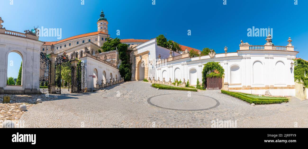 Das Schloss Mikulov, Tschechische republik. Berühmte mittelalterliche Burg auf einem Hügel. Schöner Ziergarten mit Blumen, Bäumen und grünem Gras. Sommerweide Stockfoto