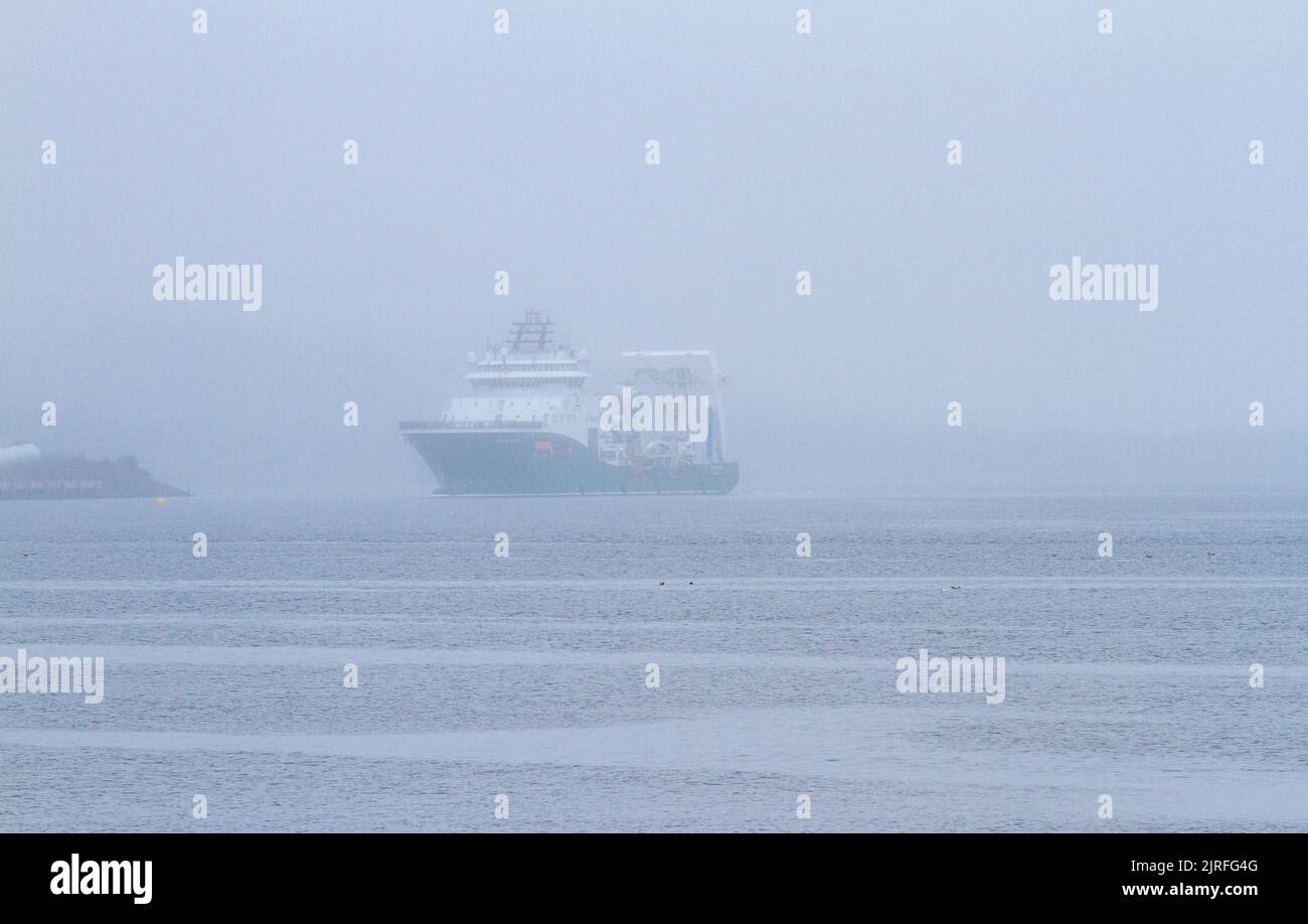 Dundee, Tayside, Schottland, Großbritannien. 24. August 2022. UK Wetter: Nordostschottland erlebt dichten Nebel und feuchte Bedingungen, mit Temperaturen bis zu 18 Grad Die Havila Phoenix, ein norwegisches Offshore-Hilfsschiff, wird sorgfältig den Tay River entlang der Dundee Docks neben der Bohrplattform Prospector 5 gesteuert. Kredit: Dundee Photographics/Alamy Live Nachrichten Stockfoto