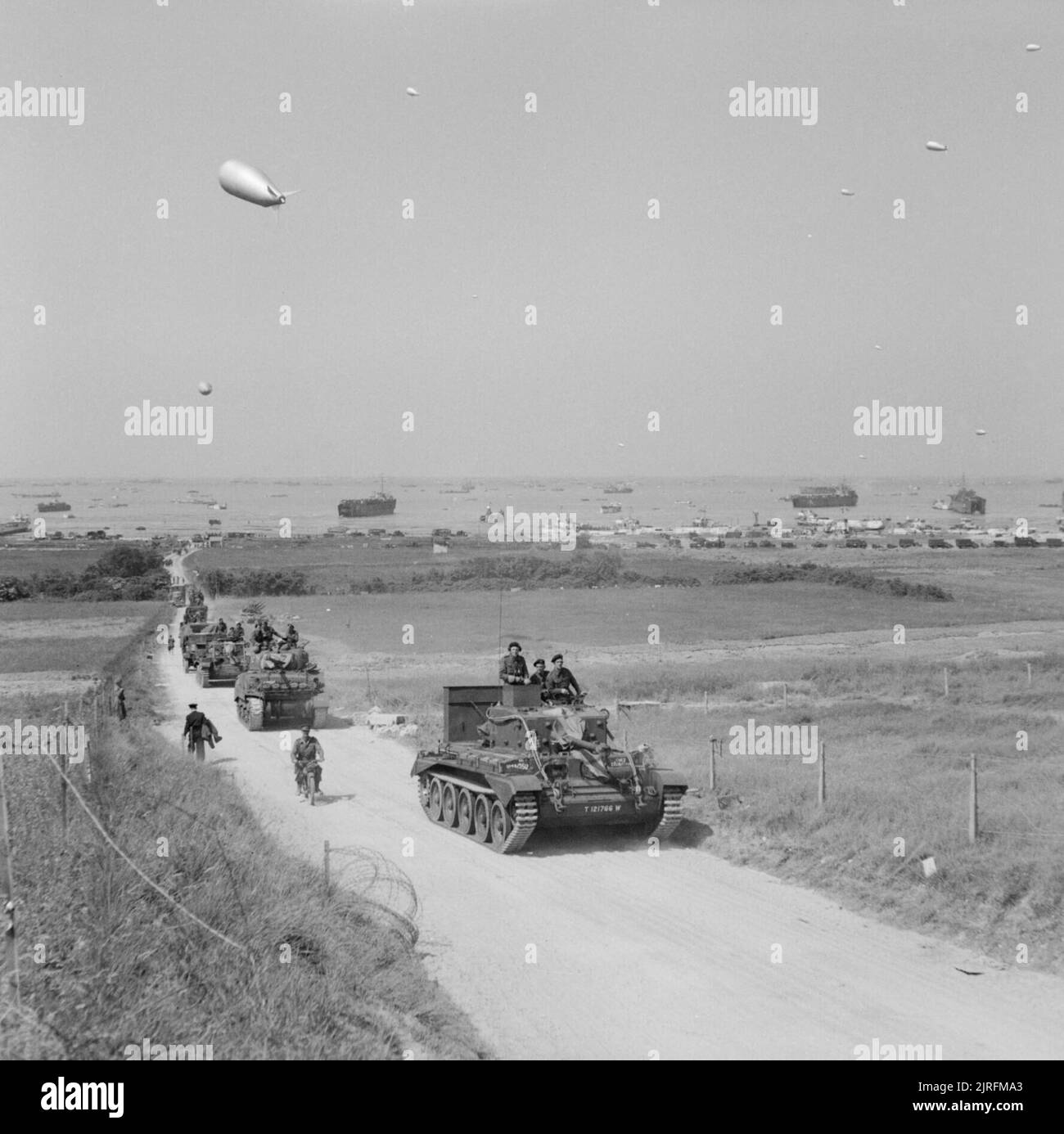 Ein Cromwell Mk V Tank von 4. County of London Yeomanry, 22. Armoured Brigade, 7. Armoured Division, führt eine Säule von Rüstungen und weichen Fahrzeugen landeinwärts von Gold Beach, Normandie, 7. Juni 1944. Ein Cromwell Mk V Tank von 4. County of London Yeomanry, 22. Armoured Brigade, 7. Armoured Division, führt eine Panzersäule (darunter ein Sherman Firefly unmittelbar dahinter) und weiche Fahrzeuge landeinwärts von King Beach, Gold Area, 7. Juni 1944. Stockfoto