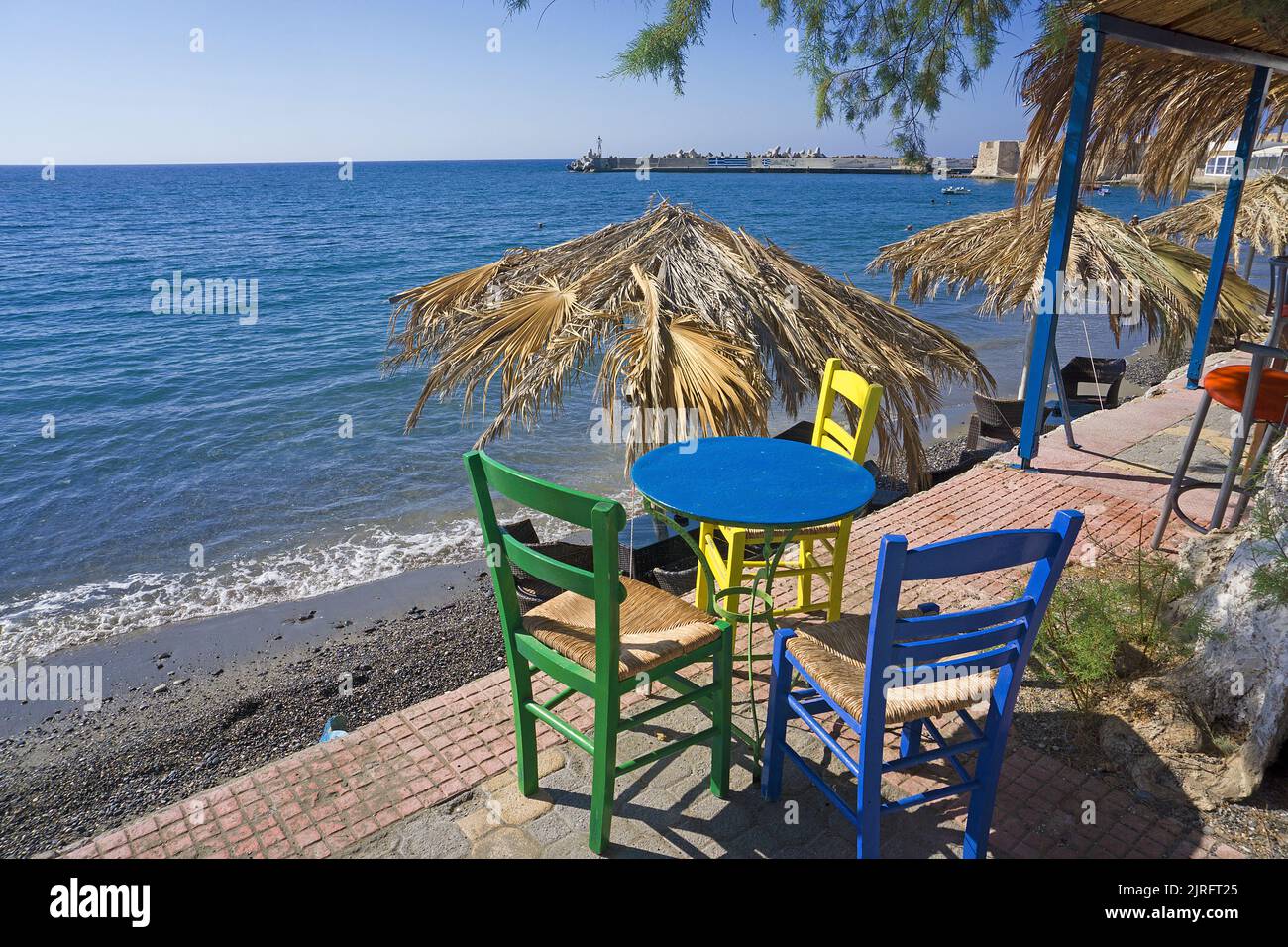 Bunte Tische und Stühle in einer Strandbar in Ierapetra, der südlichsten Stadt Griechenlands, Kreta, Griechenland, Europa Stockfoto