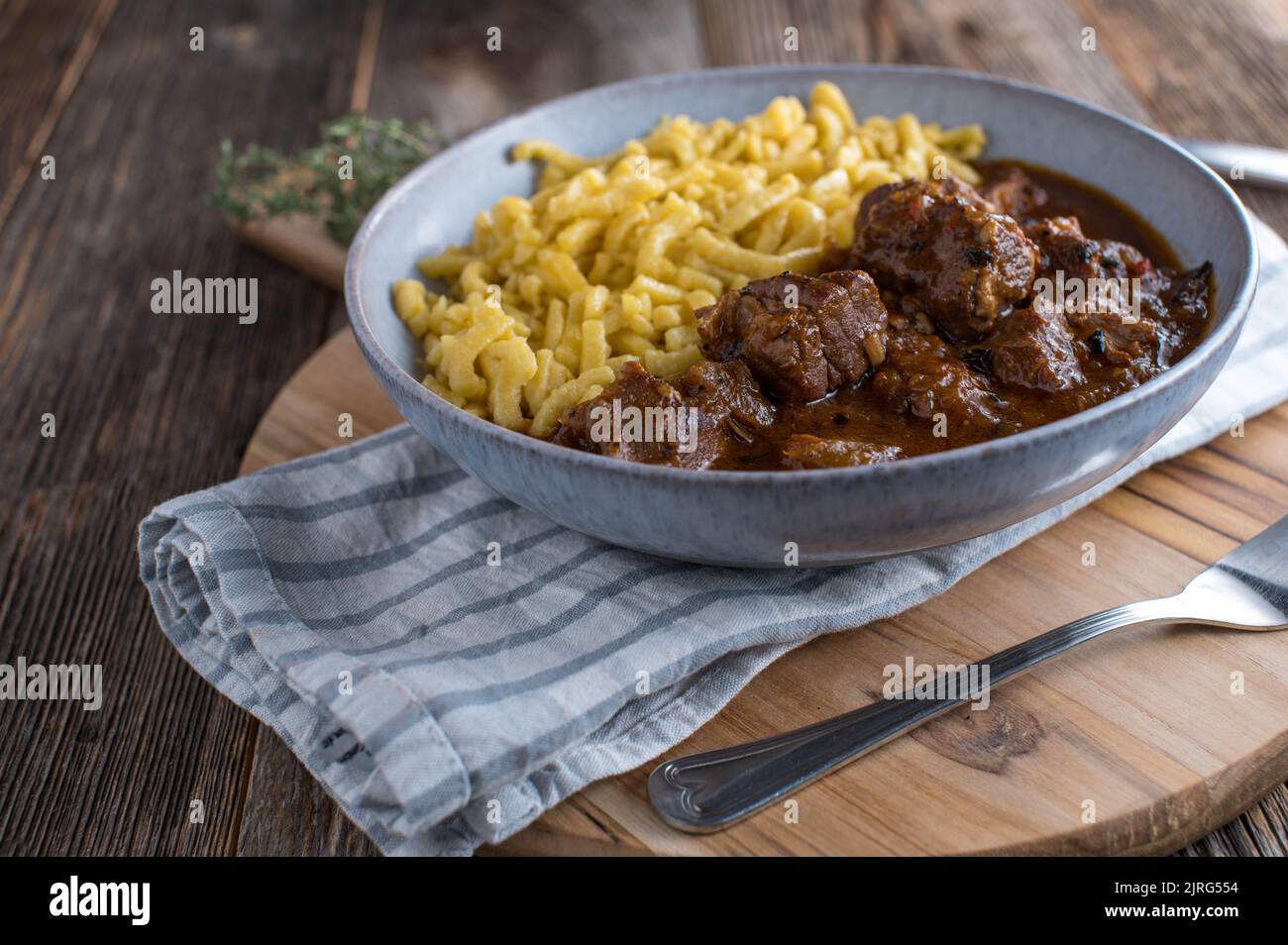 Schweinegulasch mit Spätzle-Nudeln auf einem Teller Stockfoto