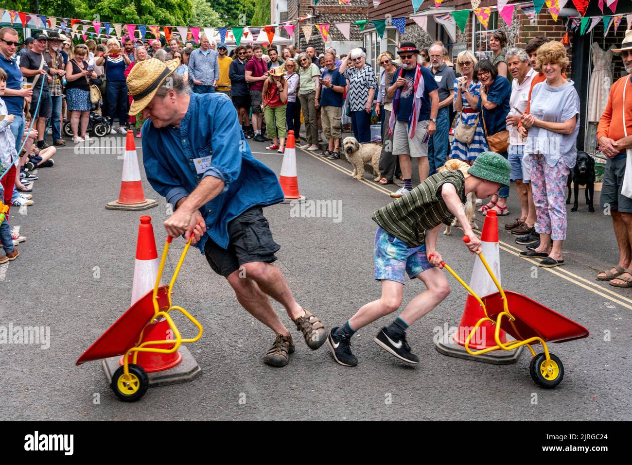 Einheimische nehmen am Wheelbarrow Racing Teil, während der South Street Bonfire Society's Annual Sports Day, Lewes, East Sussex, Großbritannien. Stockfoto
