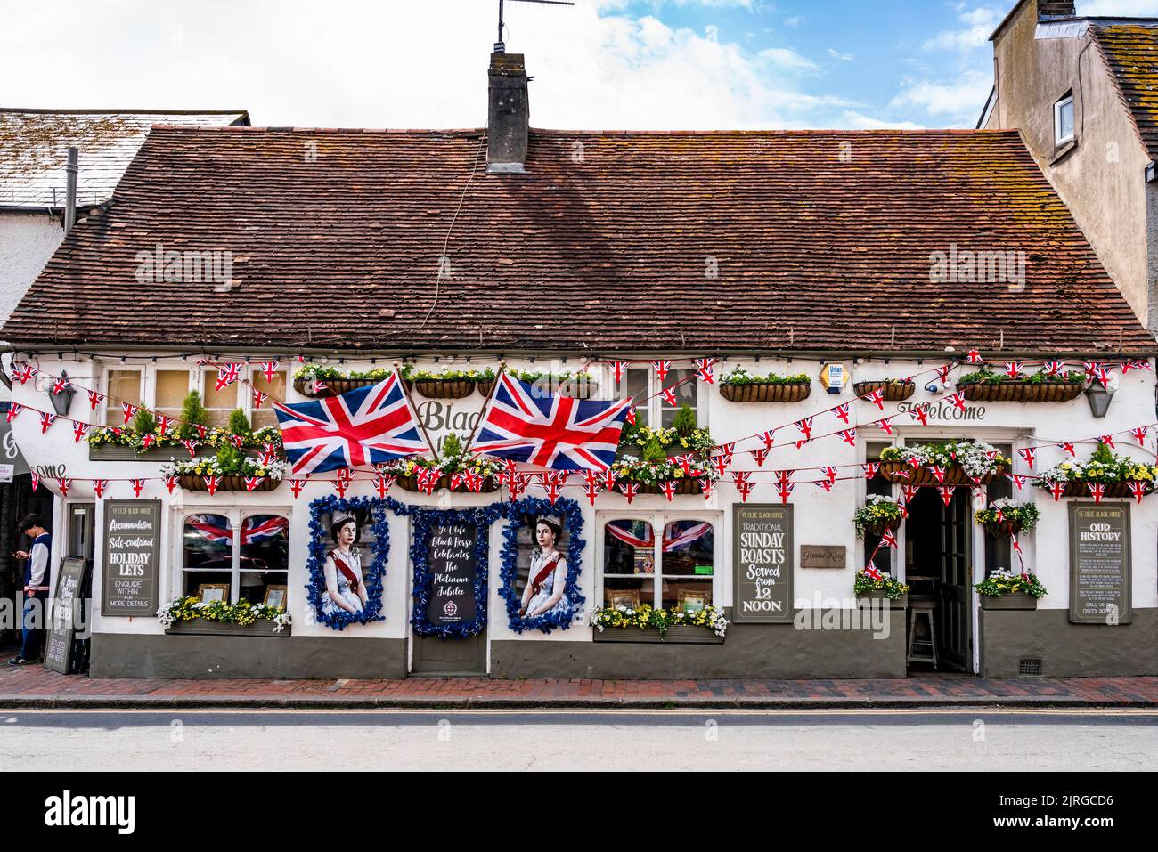 Flaggen und Porträts der Königin schmücken den Front of the Old Black Horse Pub während der Queen's Platinum Jubilee Celebrations, Rottingdean, Sussex, Großbritannien. Stockfoto Flaggen und Porträts der Königin schmücken den Front of the Old Black Horse Pub während der Queen's Platinum Jubilee Celebrations, Rottingdean, Sussex, Großbritannien. Stockfoto