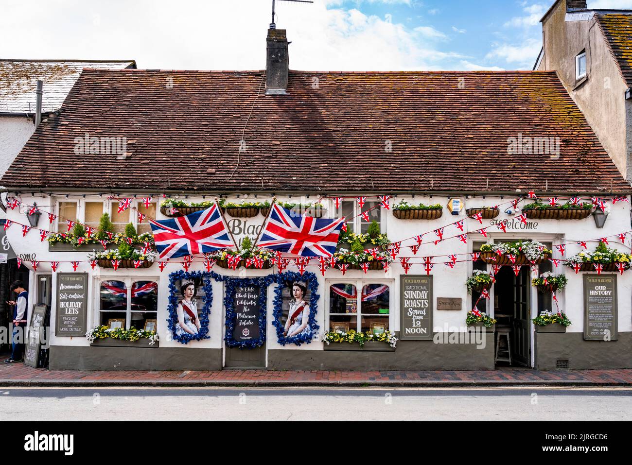 Flaggen und Porträts der Königin schmücken die Vorderseite des Black Horse Pub während der Queen's Platinum Jubilee Celebrations, Rottingdean, Sussex, Großbritannien. Stockfoto