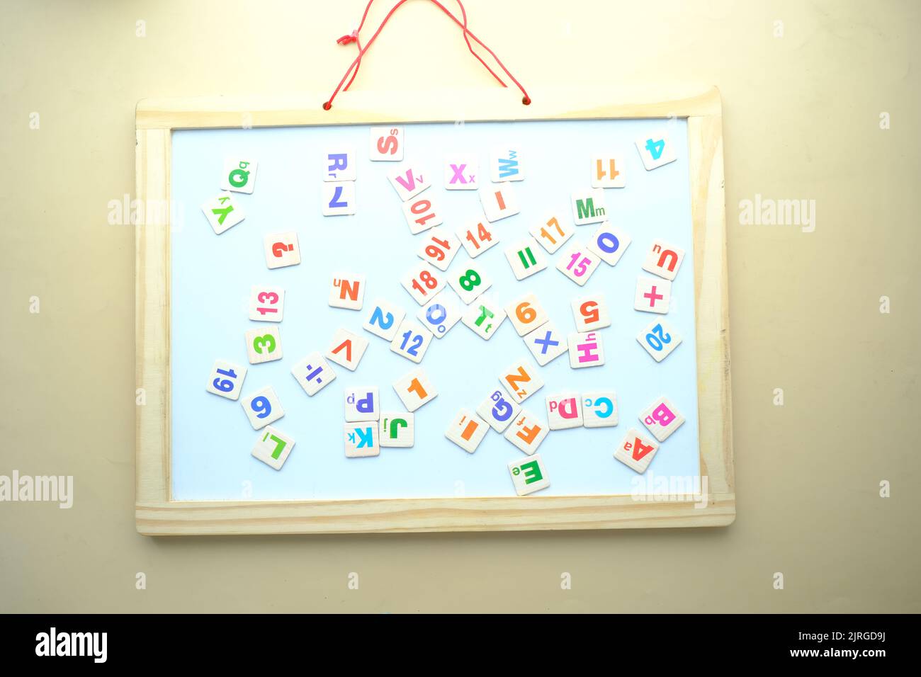 Bunte Plastikbriefe auf weißem Brett auf dem Tisch Stockfoto