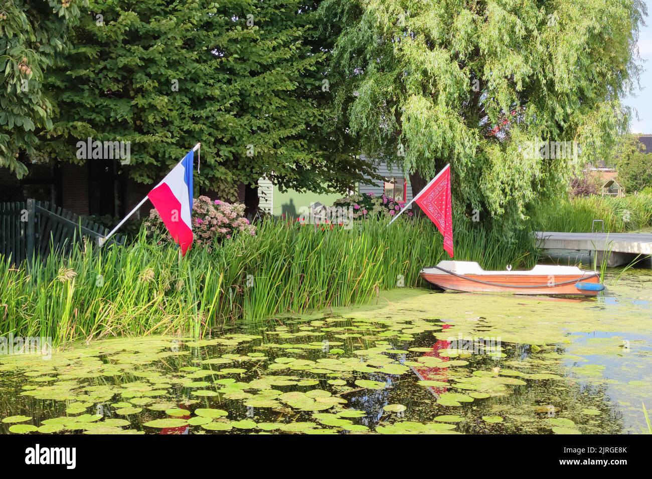 Umgekehrte niederländische Flagge und rotes Farmer-Taschentuch am Wasser. Symbol in den Niederlanden, dass die Menschen niederländische Landwirte unterstützen. Stockfoto