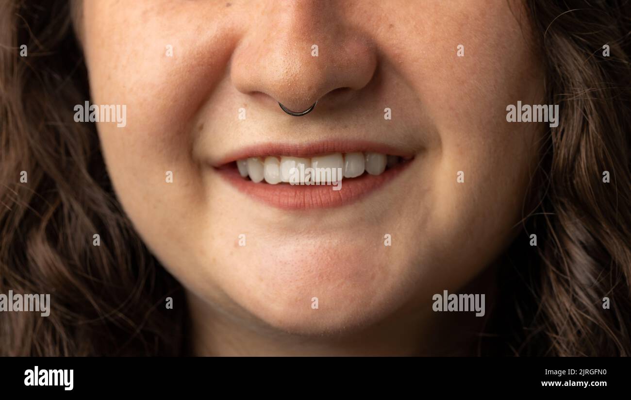Nahaufnahme einer jungen Frau mit durchbohrter Nase und lächelnd. Stockfoto