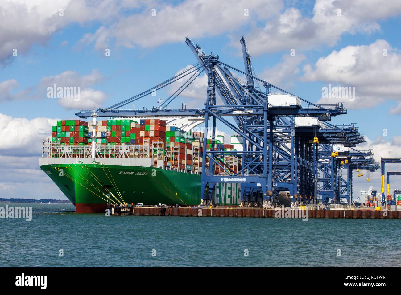 Felixstowe, UK 24 Aug 2022 die ganze Menge liegt an den Felixstowe Docks. Es ist das größte Containerschiff der Welt. Die Hafenarbeiter streiken wegen Lohnproblemen, so dass die Container erst entladen werden können, wenn das Problem gelöst ist. Hudong-Zhonghua Shipbuilding Group Co. (Hudong-Zhonghua), eine Tochtergesellschaft der China State Shipbuilding Corporation (CSSC), baute und lieferte das größte Containerschiff der Welt an die taiwanesische Reederei Evergreen Marine. Das Ever alot Schiff hat eine Tragfähigkeit von 24.004 TEU und misst 400 Meter lang und 61,5 Meter breit, mit einem Tiefgang von 17 Metern. Der Riese Stockfoto