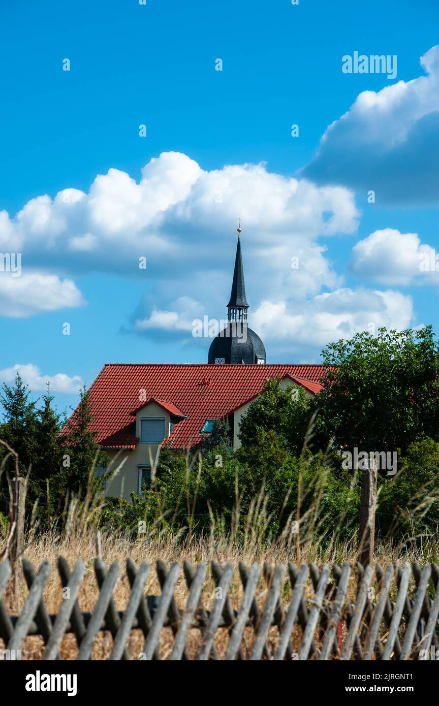 Calvorde, Deutschland - 6. August 2022: Haus und Glockenturm der Evangelischen Kirche in Calvorde, Sachsen-Anhalt, Deutschland Stockfoto