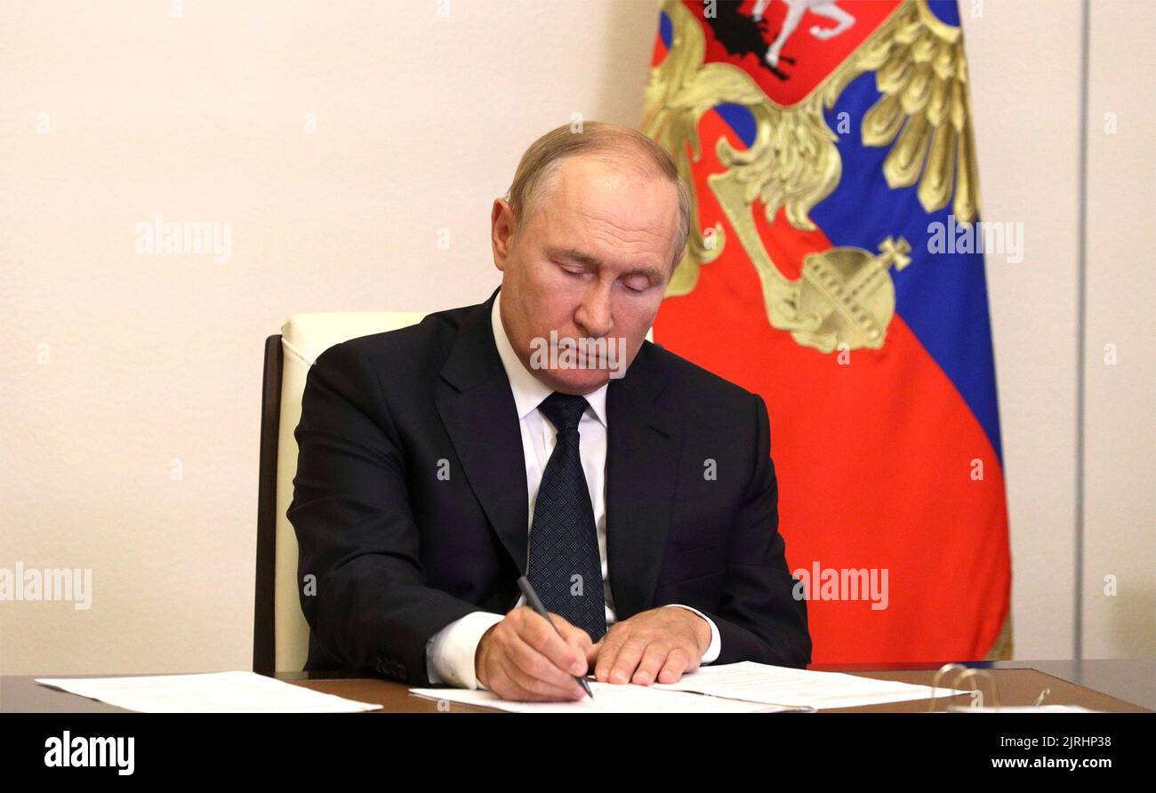 Novo-Ogaryowo, Russland. 24. August 2022. Der russische Präsident Wladimir Putin macht sich Notizen während eines virtuellen Treffens mit den Beamten des Notdienstes, um die Reaktion auf Waldbrände während des gesamten Landbezirkes vom offiziellen Wohnsitz von Novo-Ogarjovo am 24. August 2022 im Moskauer Gebiet, Russland, zu besprechen. Durch das trockene heiße Wetter haben sich Waldbrände in den Regionen Rjasan und Nischni Nowgorod sowie in der Republik Mari El ausgebreitet. Quelle: Mikhail Klimentyev/Kremlin Pool/Alamy Live News Stockfoto
