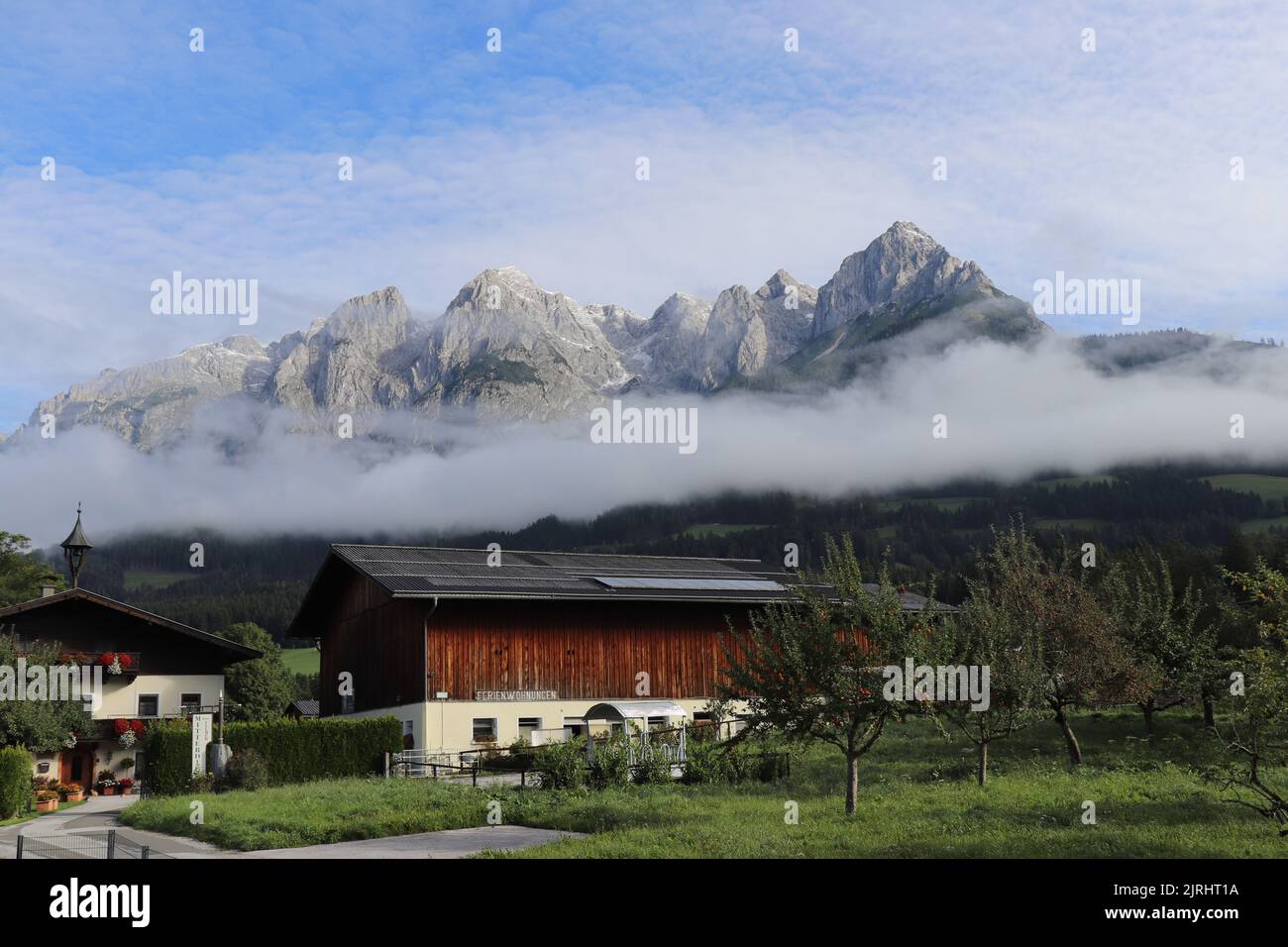 Landhaus in einer kleinen Stadt in Deutschland mit einer schönen Berge auf der Rückseite und den Wolken perfekt eine Linie auf dem Dach des Hauses. Ländliches Hotel Stockfoto