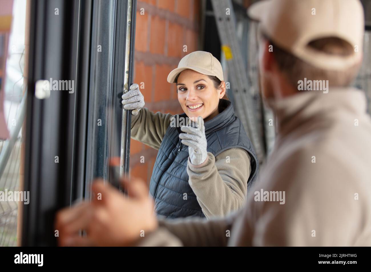 Eine Baufrau im Gespräch mit einem männlichen Kollegen Stockfoto