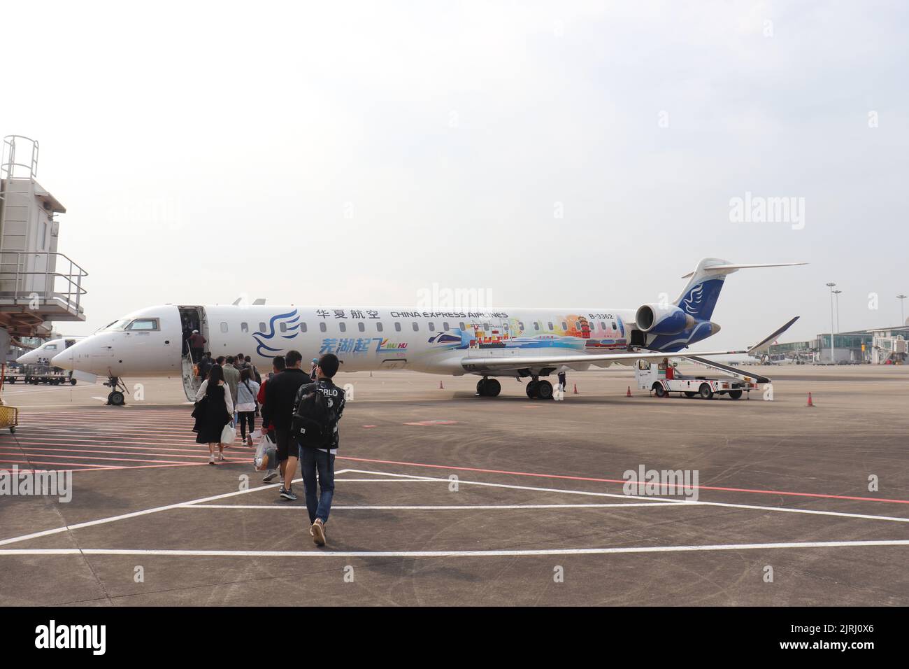 Eine Gruppe von Leuten, die auf dem Flughafen in ein Flugzeug steigen Stockfoto