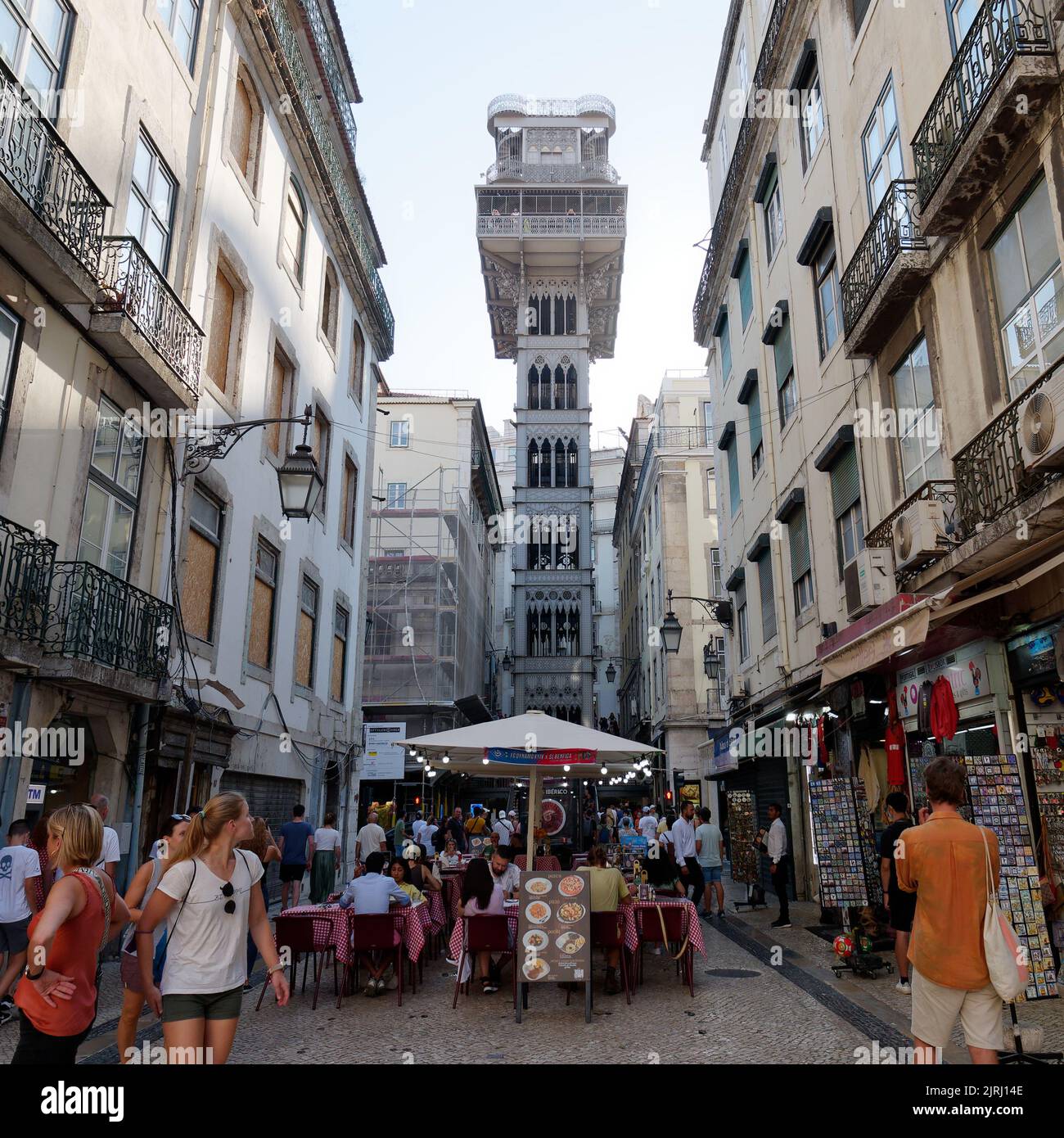 Santa Justa Lift in Lissabon, Portugal. Touristen gehen durch die Straßen und essen in den Restaurants. Stockfoto