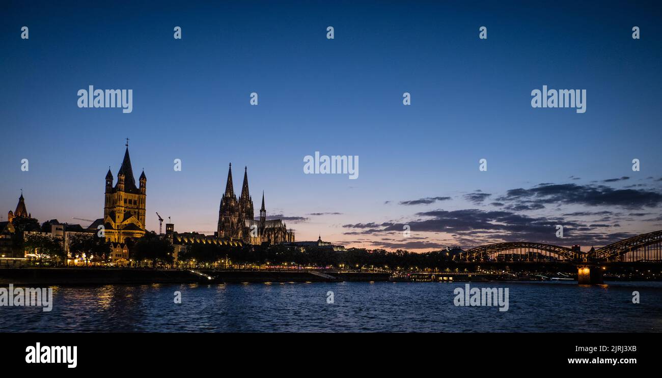 Landschaftsbild der Martinskirche und des Kölner Doms am Abend mit der Hohenzollernbrücke im Hintergrund Stockfoto