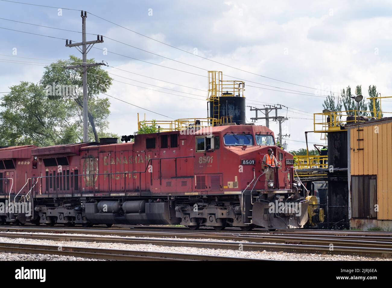 Franklin Park, Illinois, USA. Mit einem Besatzungsmitglied, das auf der vorderen Plattform der Bleilokomotive fährt, kommt ein Güterzug auf einem Eisenbahnhof an. Stockfoto