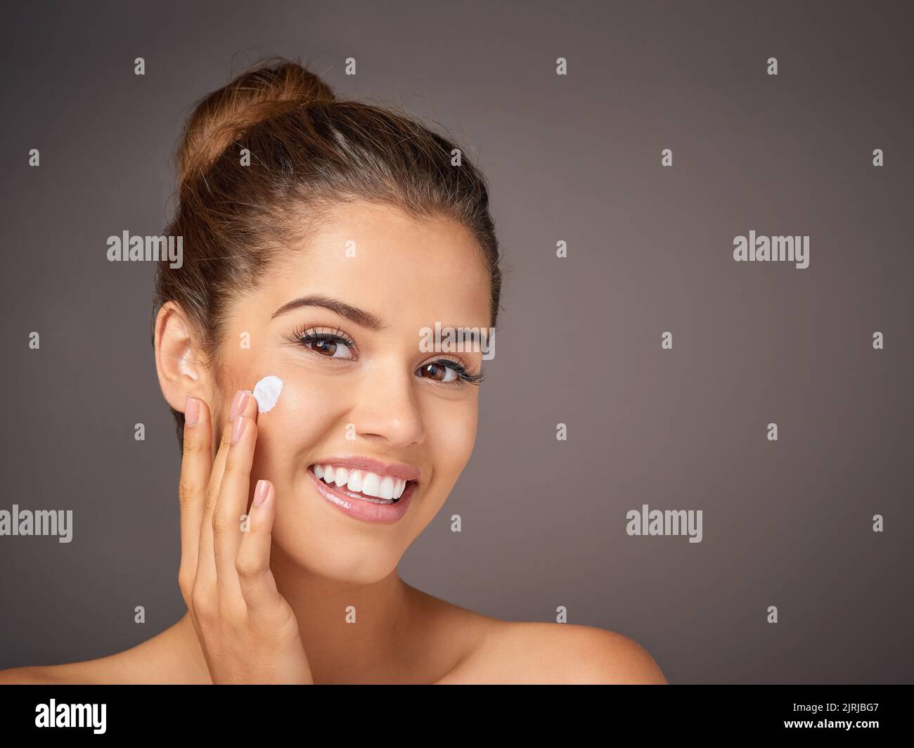 Die beste Kosmetik ist toll aussehende Haut. Porträt eines jungen Models, das im Studio Feuchtigkeitscreme auf ihr Gesicht anwendet. Stockfoto