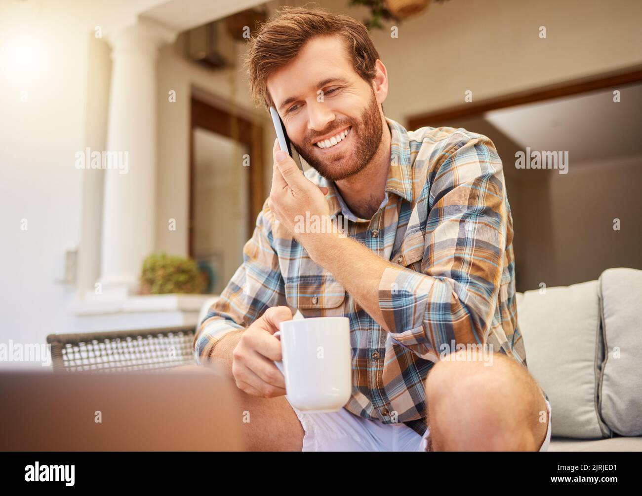 Kommunikation, Kaffee und Mann mit Telefon auf dem Sofa, um im Wohnzimmer zu entspannen. Erfolg, Internet und Arbeit von zu Hause aus mit Tee. Glücklicher Mann, der sitzt Stockfoto