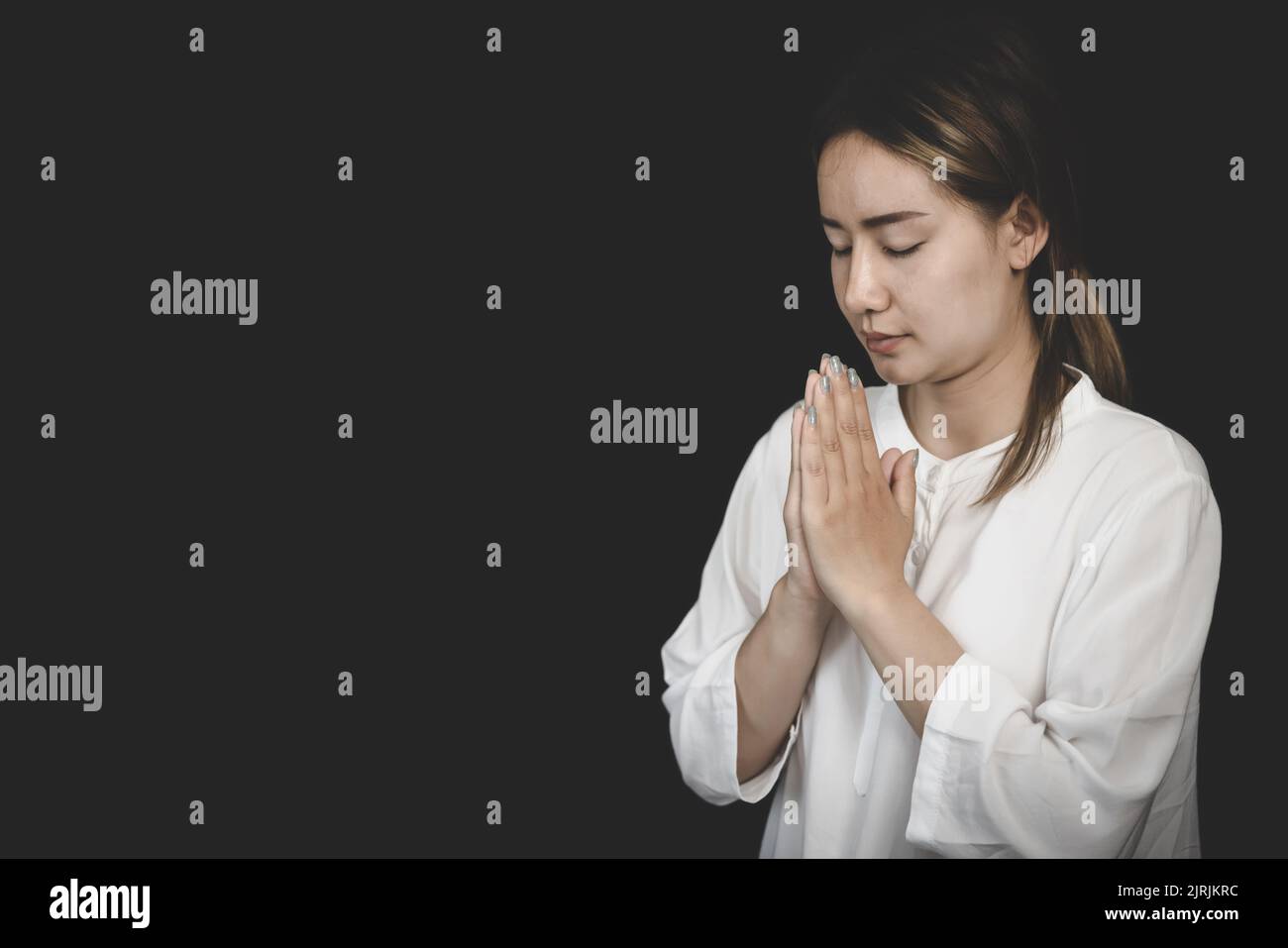 Eine Frau faltete ihre Hände, um Segen zu beten und zu Gott zu beten. Beten für spirituelle Überzeugungen. Die Kraft der Hoffnung oder Liebe und Loyalität. Vertrauen in goo Stockfoto
