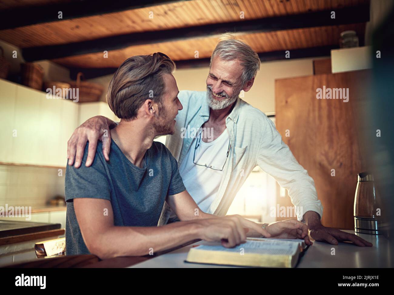 Jeder braucht einen spirituellen Mentor. Ein Vater und ein Sohn machen gemeinsam zu Hause Bibelstudien. Stockfoto